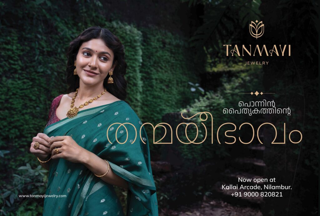 Ad director in Kerala creates Tanmayi Jewellers ad featuring an elegant woman in a green saree adorned with traditional gold jewelry, set against a lush natural backdrop to highlight timeless beauty.