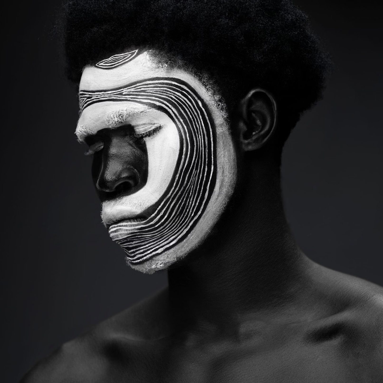 Portrait with bold black-and-white geometric face paint.