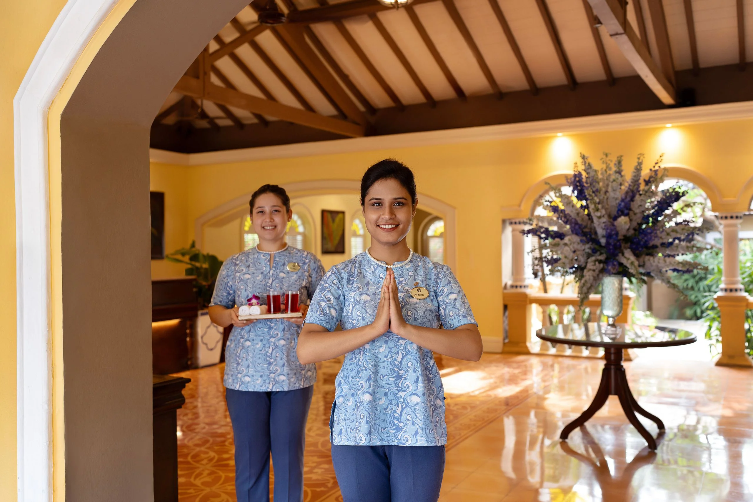 Warm hotel welcome with staff greeting guests at reception.