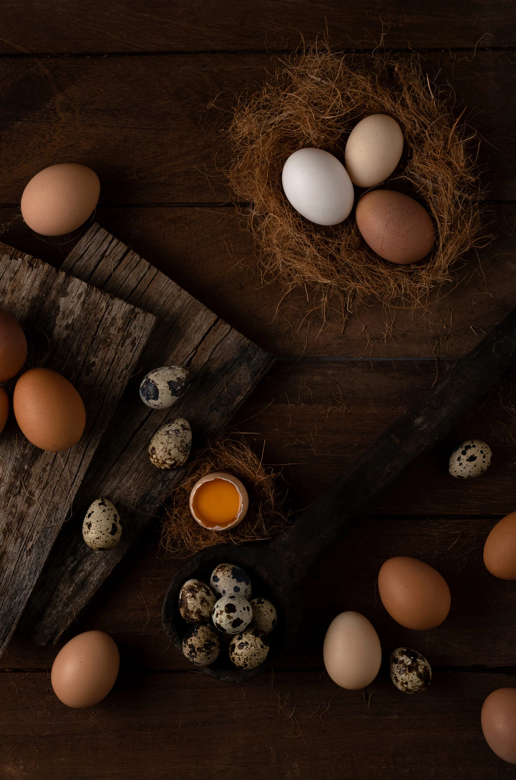 Assorted eggs arranged on rustic wooden surfaces.