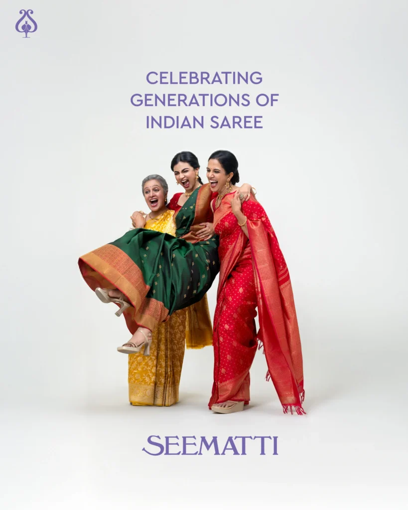 Three women joyfully celebrating in colorful sarees.