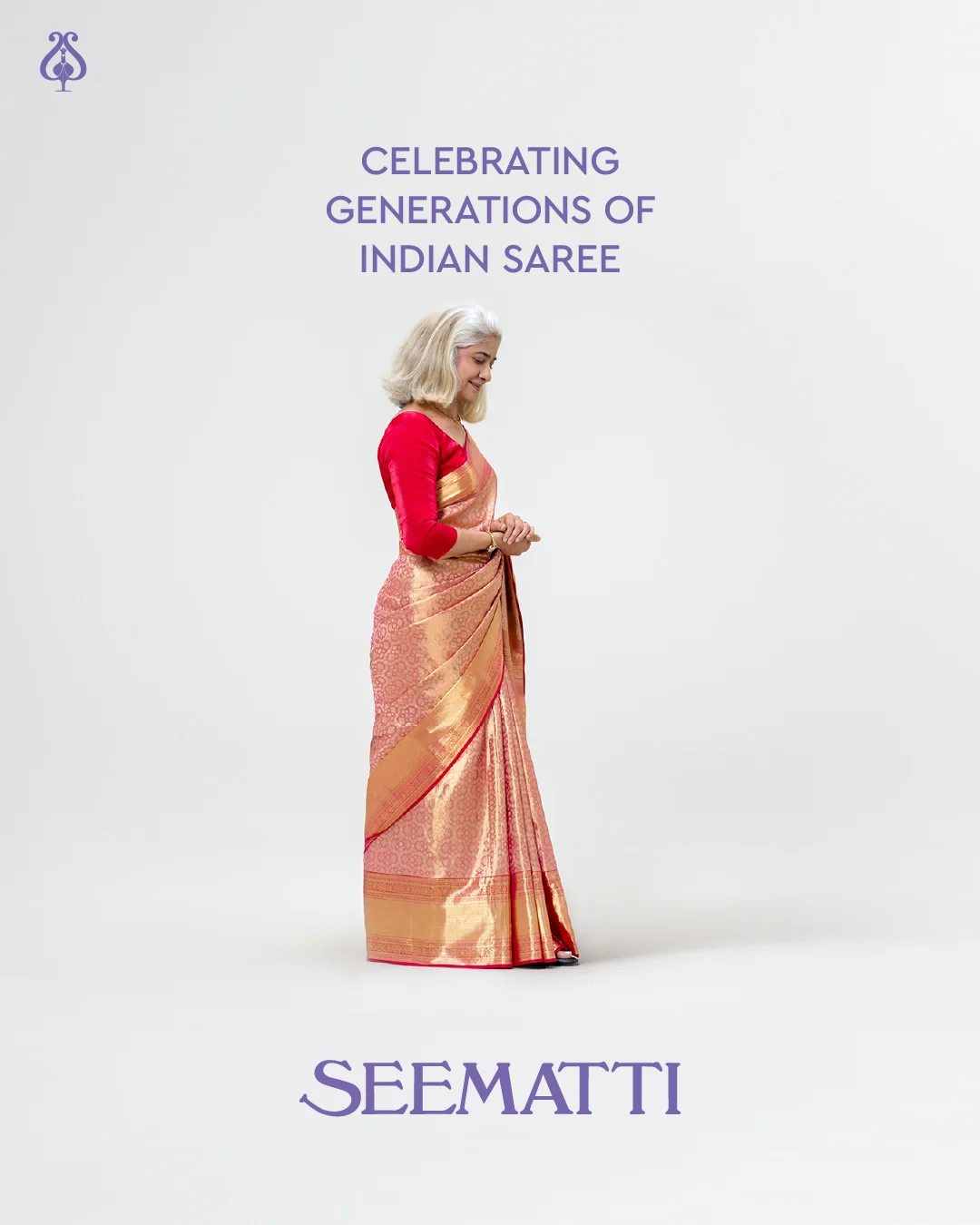 Older woman smiling in a pink and gold saree.