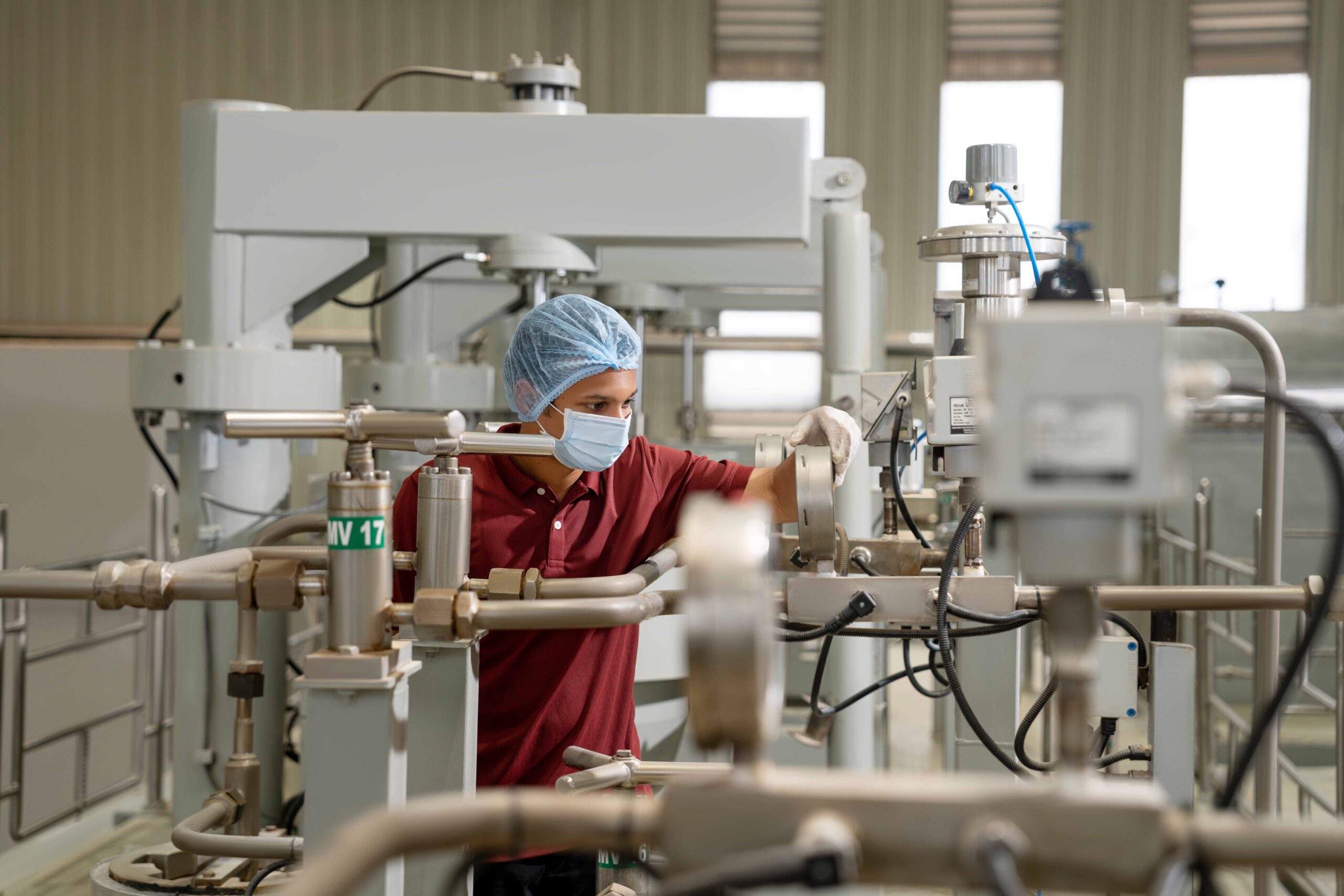 Factory worker operating industrial machinery in a manufacturing facility.