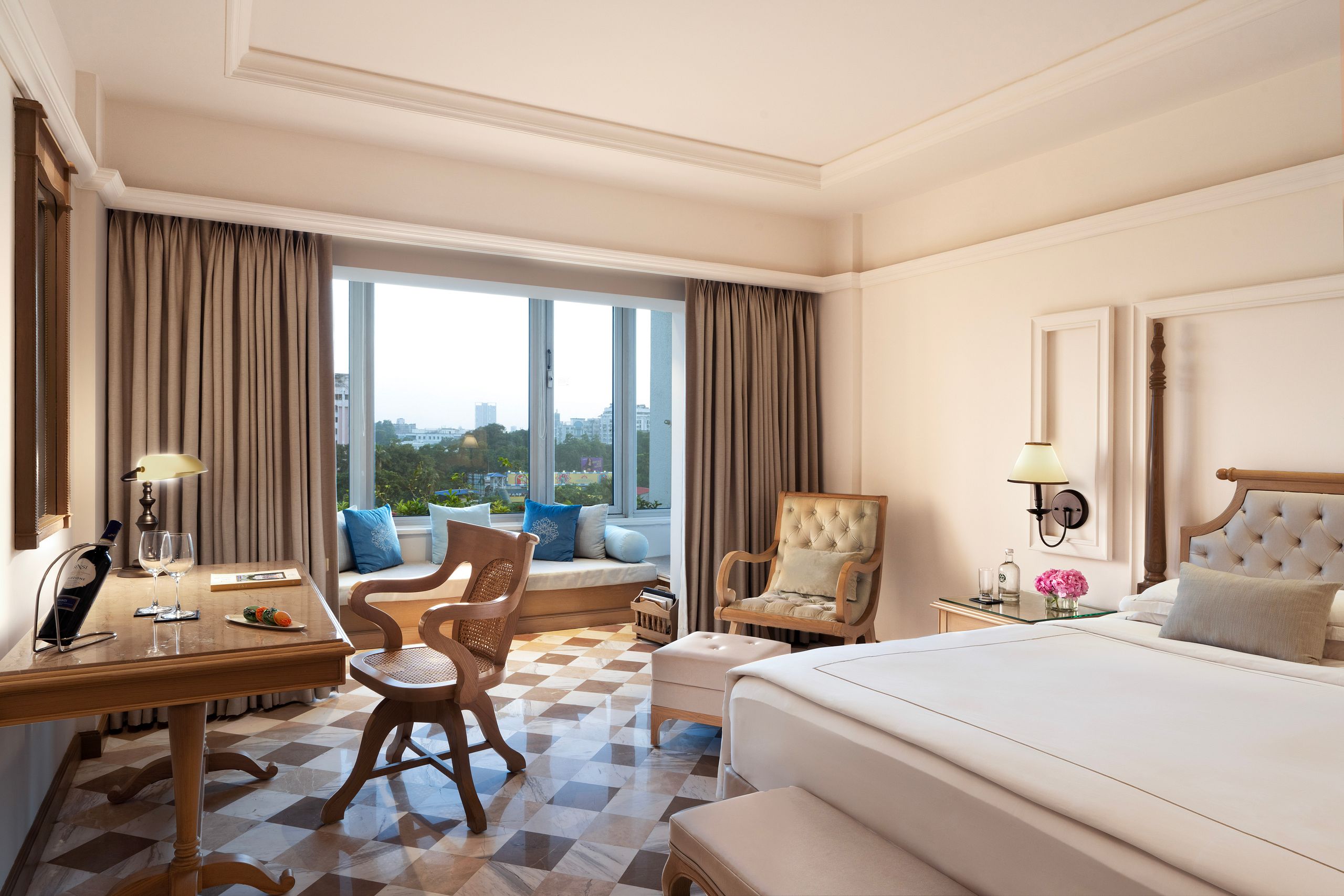 Elegant hotel room with a large bed, seating area, and window view.