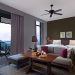 Cozy twin-bed room with balcony and scenic mountain view.